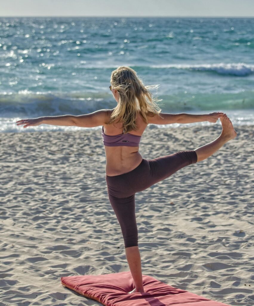 Une femme faisant du yoga sur la plage, profitant du soleil de l'Ile d'Aix